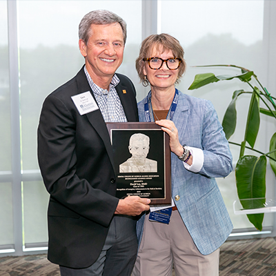 Dental College of Georgia Dean Nancy Young presents the 2024 Distinguished Alumni Award to Dave Lee, DMD