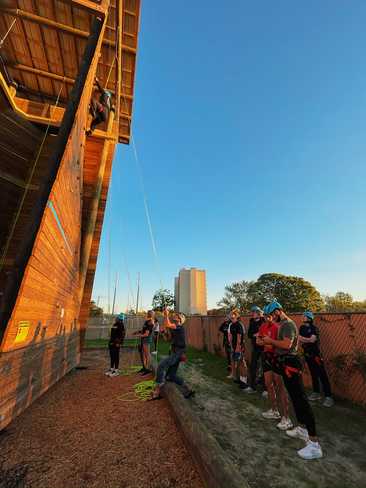 Two students climbing the tower in harnesses