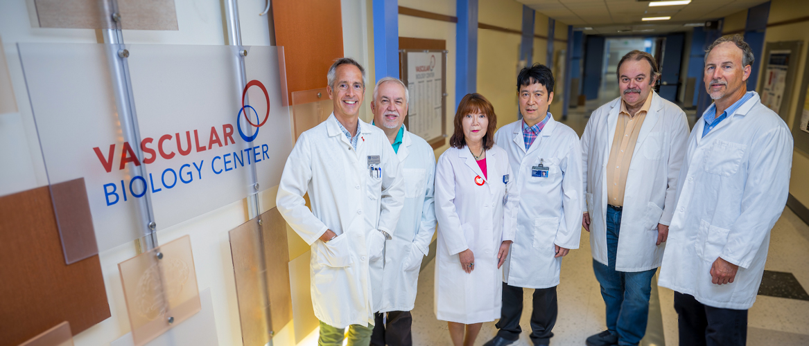 VBC members pose for a picture next to their VBC sign in a building