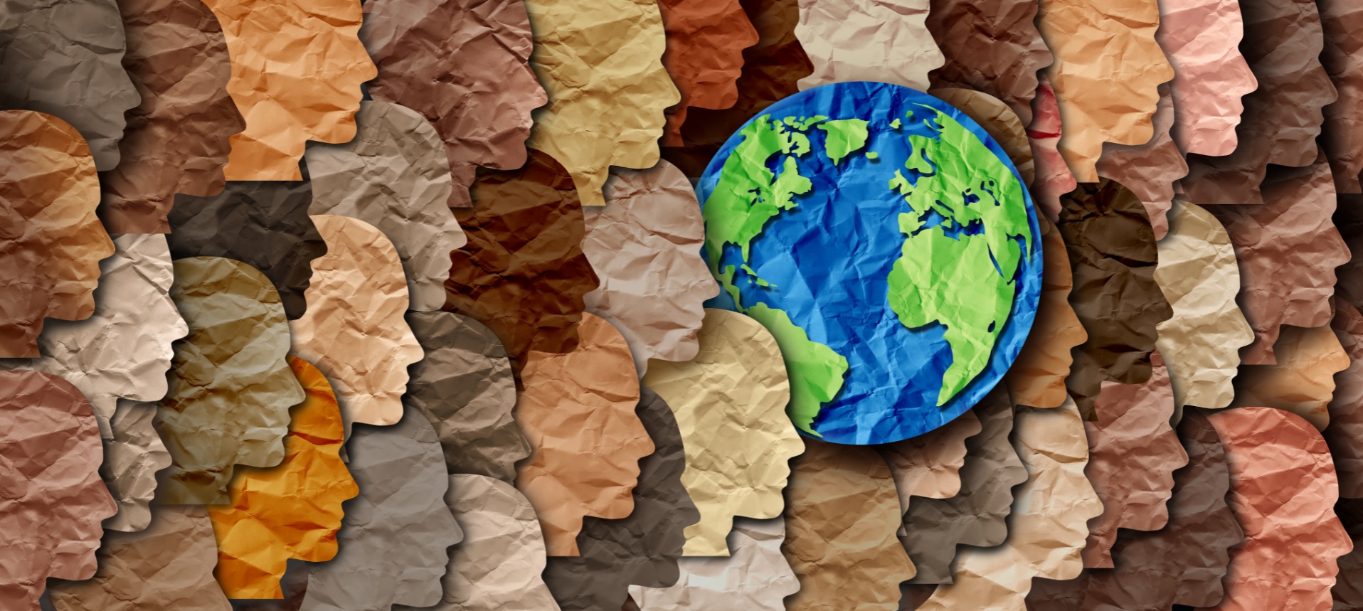 silhouette of diverse colored paper faces with a depiction of the earth