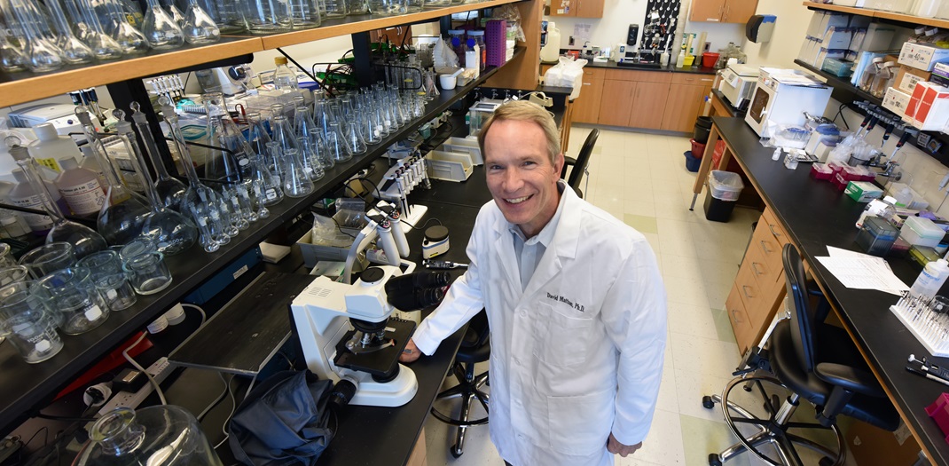 David Mattson posing and smiling for the camera in his lab.