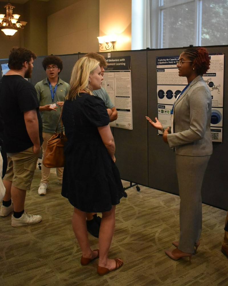 Female research student speaking to a woman and man 