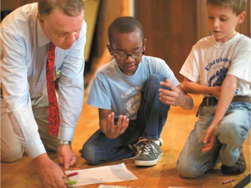 teacher teaching two students