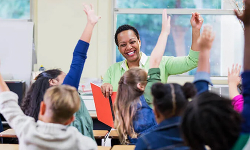 Teacher in front of a classroom full of raised hands