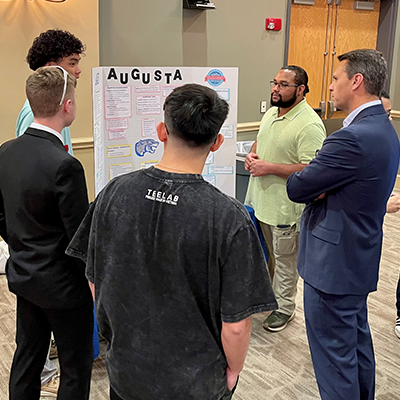 Dean of Students Scott Wallace listens to INQR students presenting their findings