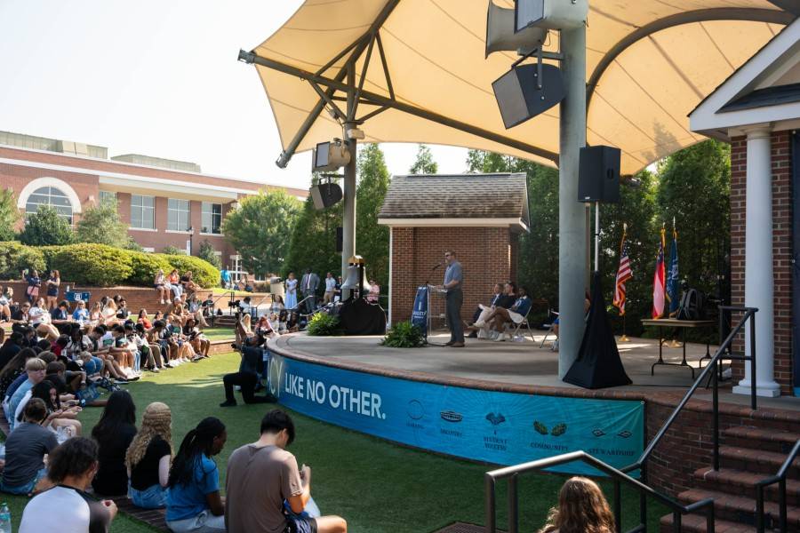 man speaking at podium on amphitheater stage