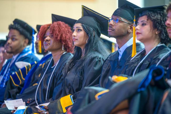 Graduate students in caps and gowns at commencement