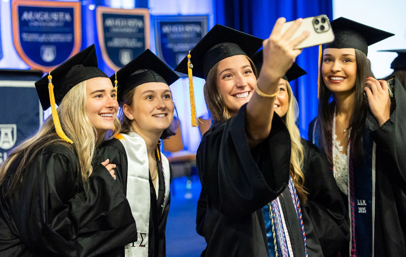 Five female students looking at a phone screen