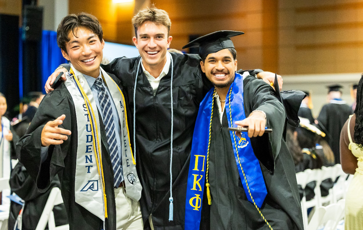 Three male students in caps and gowns