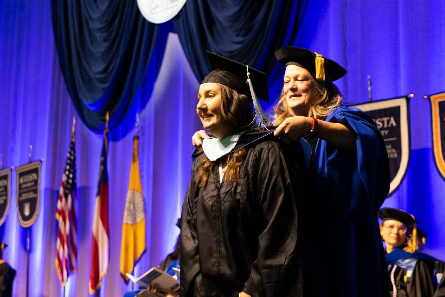 Faculty member hooding a graduate