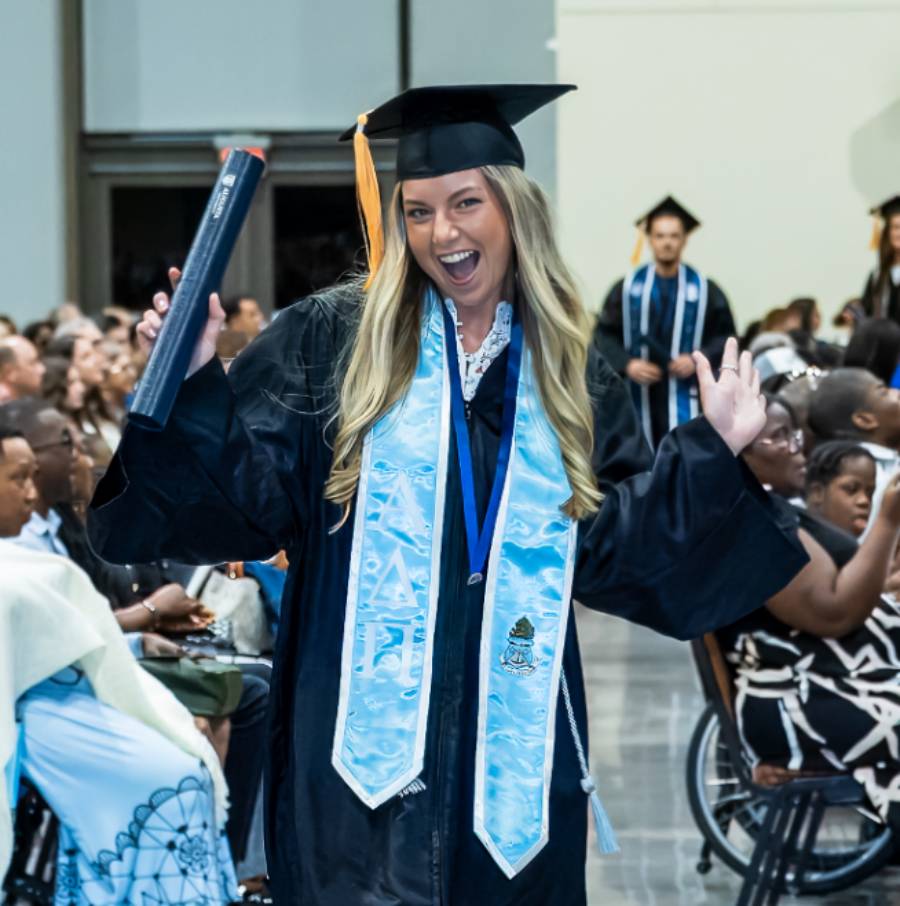 Excited graduate holding diploma tube