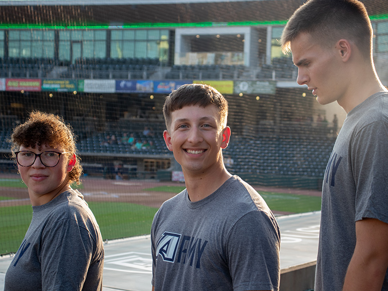 Cadet smiles at camera at SRP Park, wearing AU ROTC shirt