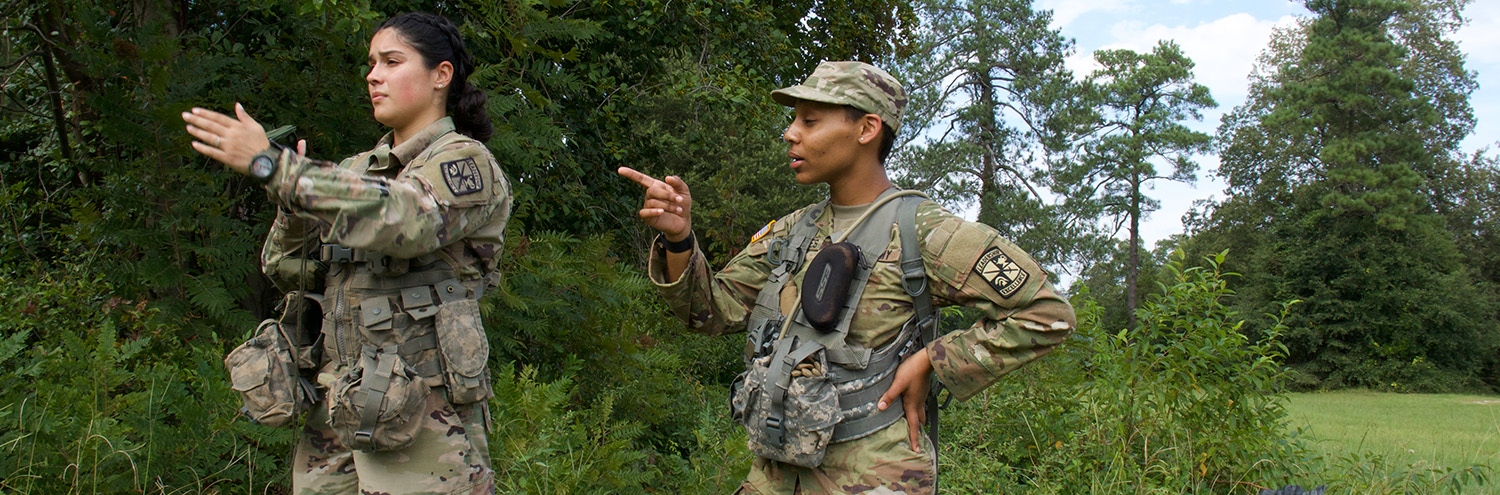 2 Cadets look and point to the left toward an objective