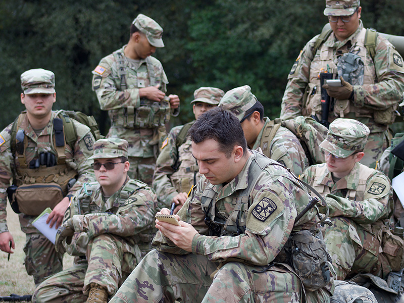 Cadet writes on notepad at the front of a group of other cadets