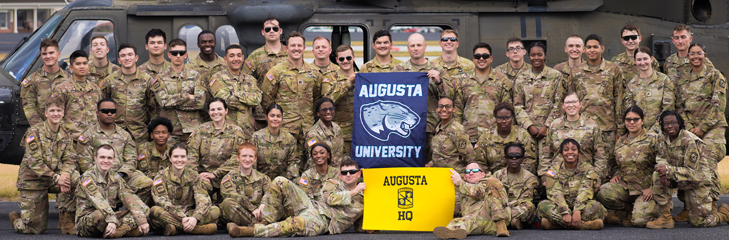 Jaguar Battalion group standing in front of Army helicopter with flags