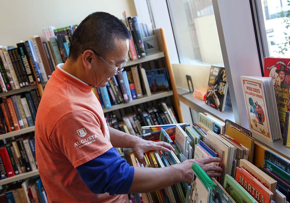 Male organizing books during day of service