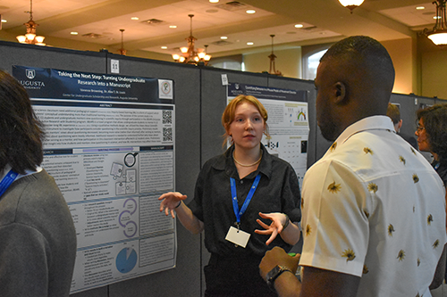 Two people discussing a research poster