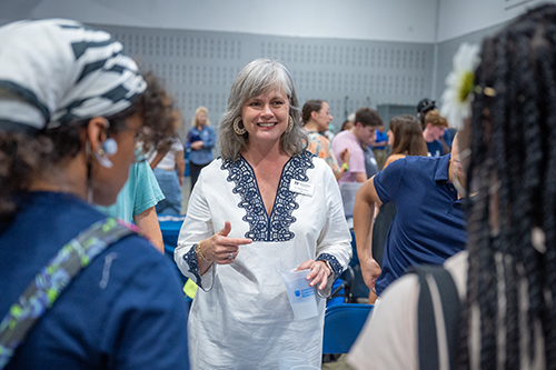 Woman speaking to two students